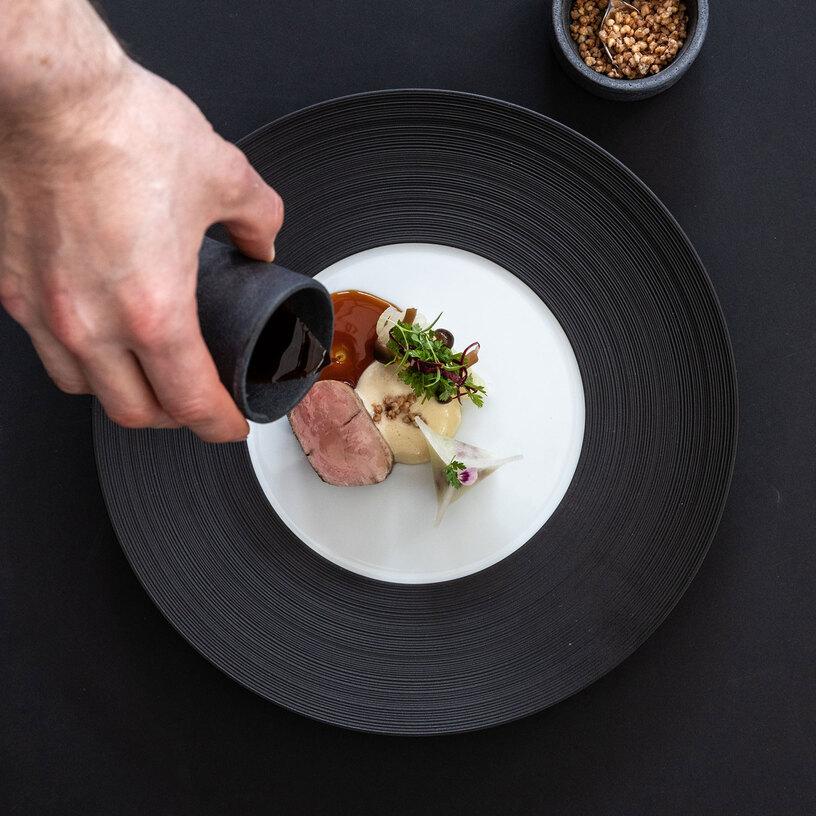 Gericht angerichtet auf schwarzem Teller