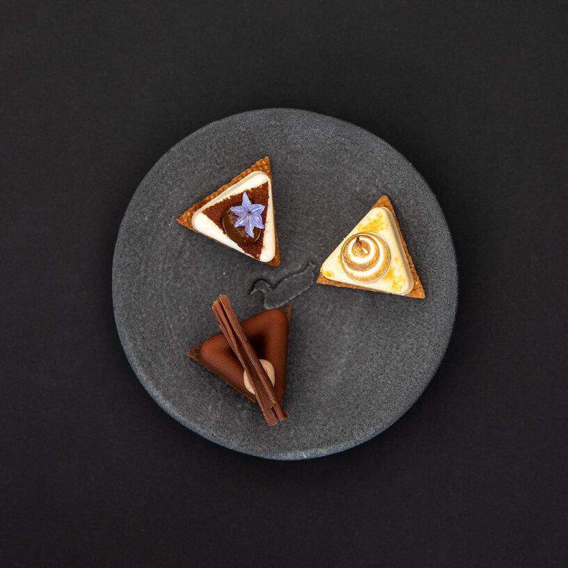 Gericht angerichtet auf schwarzem Teller