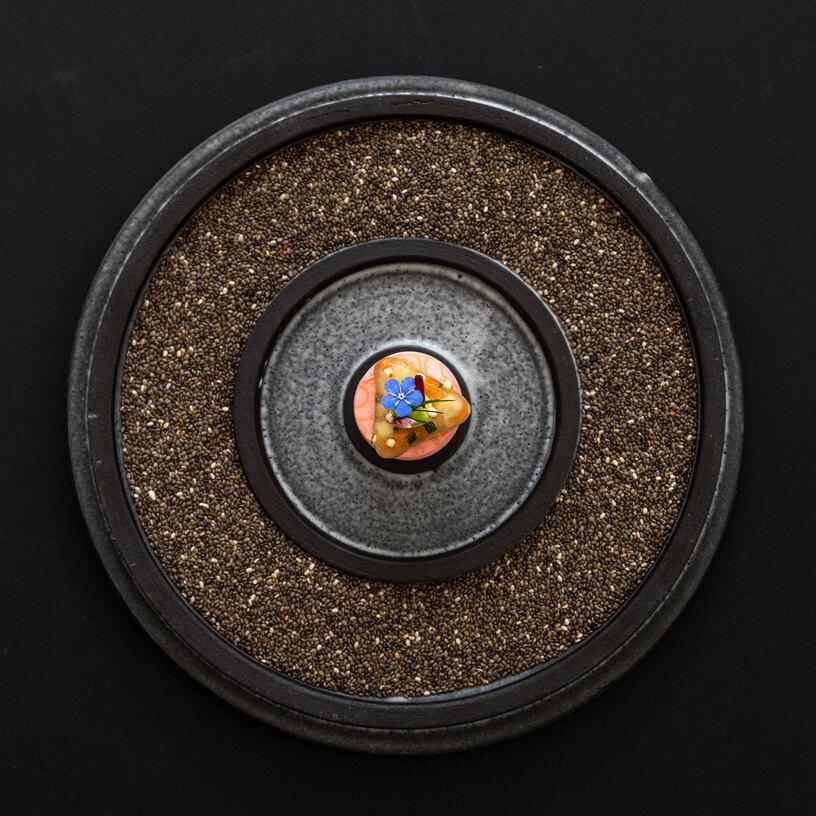 Gericht angerichtet auf schwarzem Teller